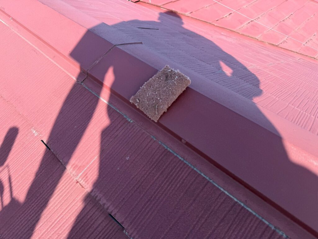 棟板金ケレン<br />
（ケレンとは、塗料との密着を良くするために、専用の道具で細かい傷をつける下地調整です。）